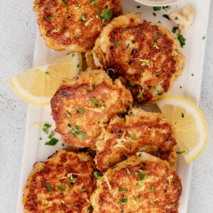 Crab cakes on a white tray with lemon slices