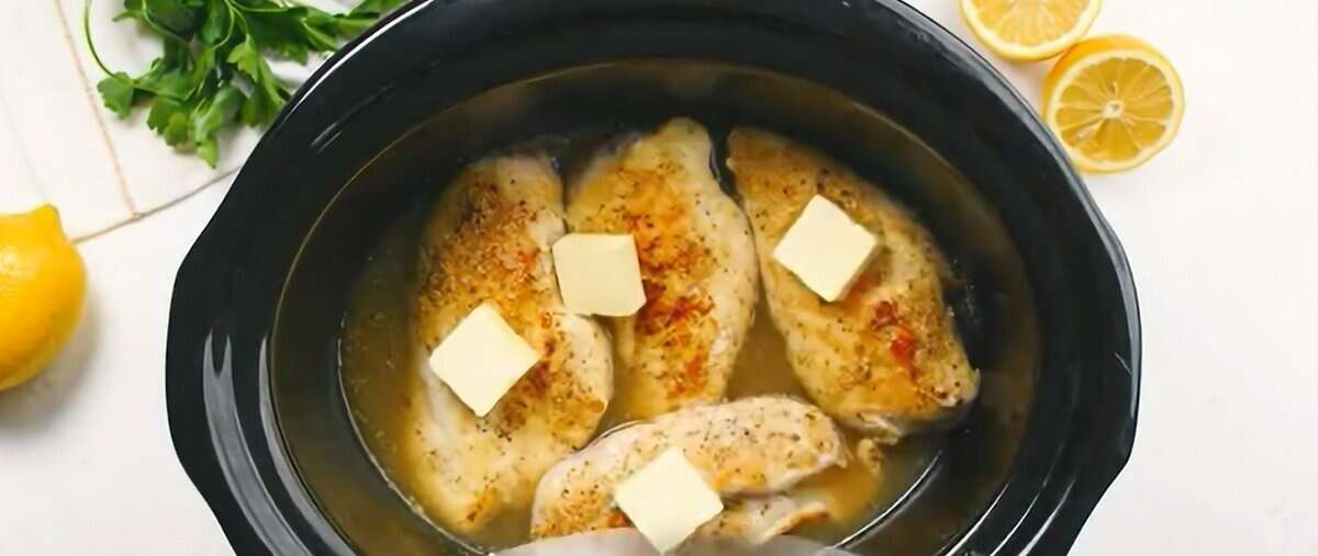 Chicken with lemon juice, chicken broth, and pats of butter in the crockpot.