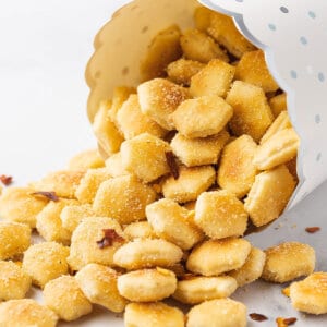 A cup of spilled oyster crackers with crushed red pepper flakes
