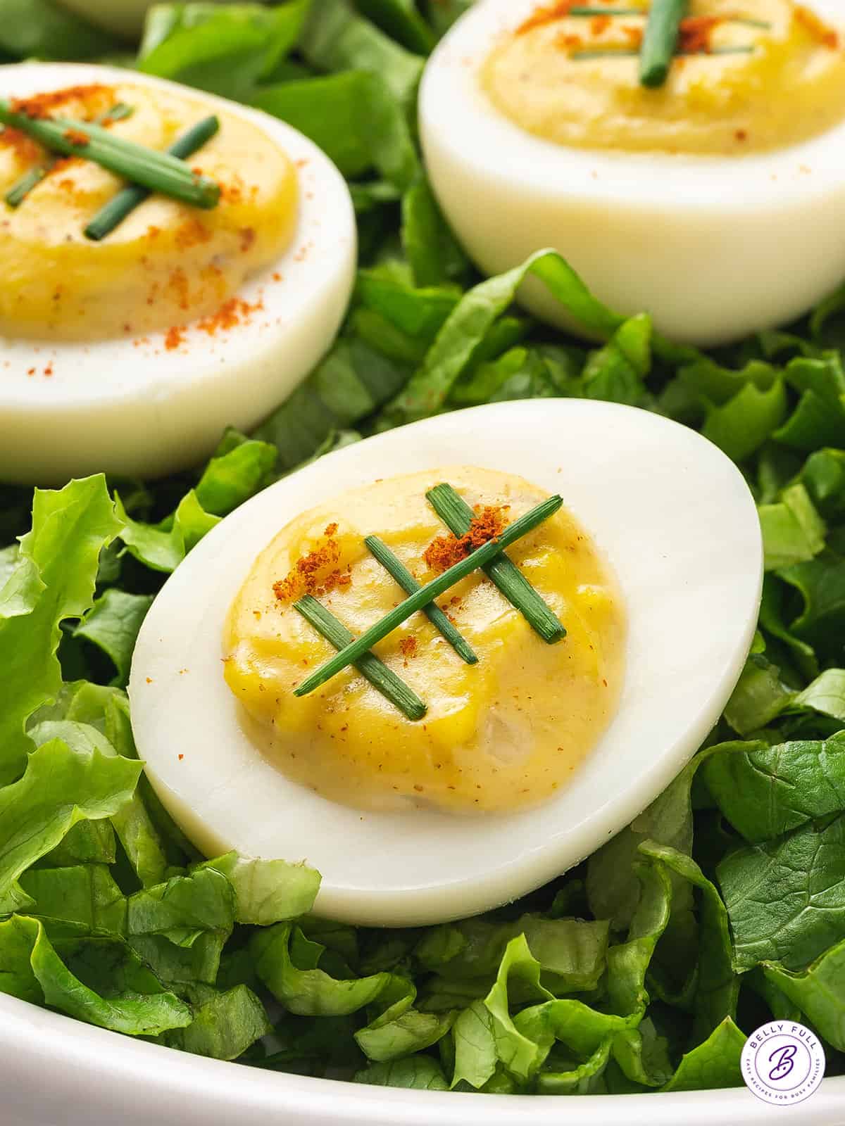 close up deviled egg with strips of scallions