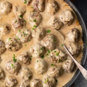 Overhead view of a skillet of gravy smothered Swedish meatballs