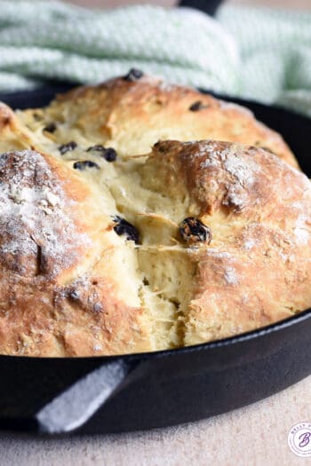 baked loaf of bread in cast iron skillet