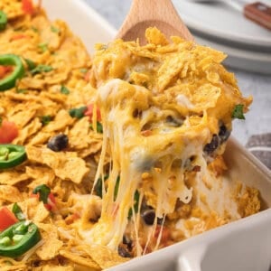 A wooden spoon serving a scoop of nacho chicken casserole
