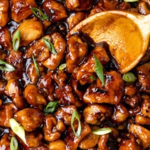 A wooden spoon stirring homemade bourbon chicken