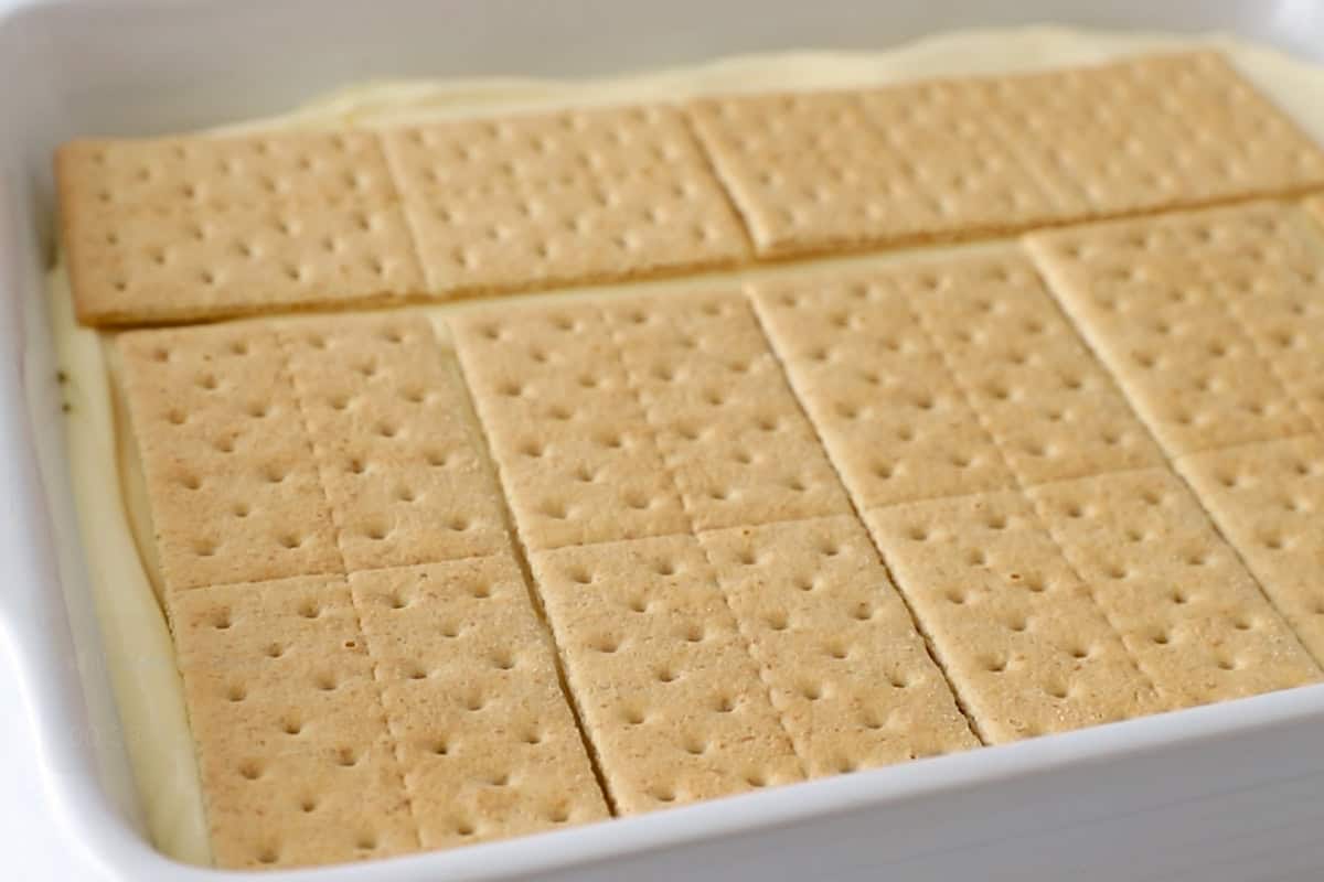 a layer of graham crackers over vanilla pudding in casserole dish