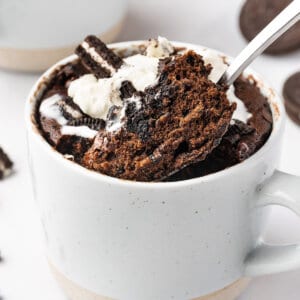 A spoon lifting a bite out of an Oreo microwave cake