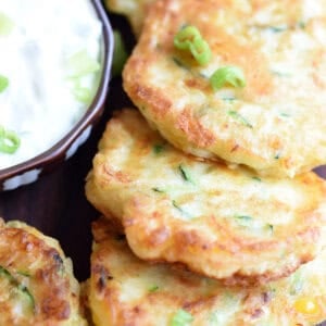 pile of zucchini corn fritters with dipping sauce