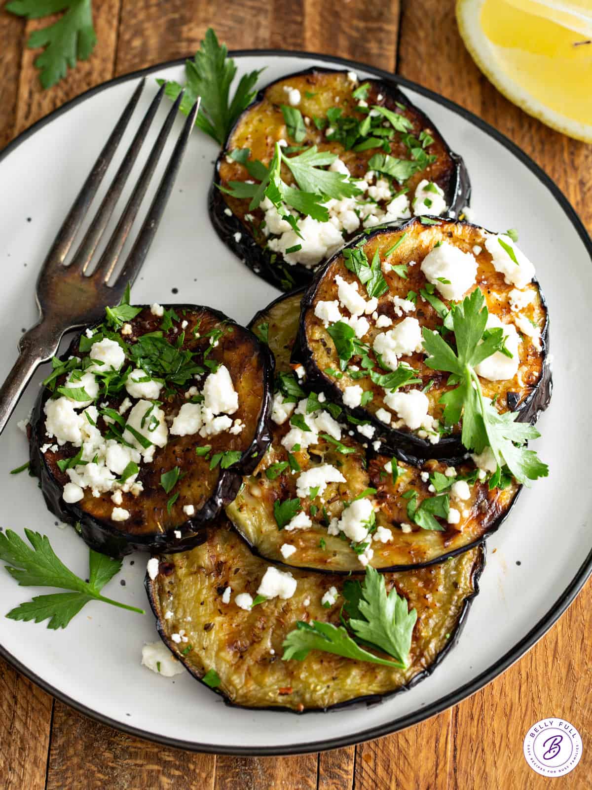 plate of grilled eggplant with feta cheese and parsley