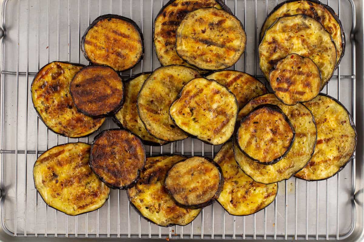 Grilled eggplant slices on a cooling rack.