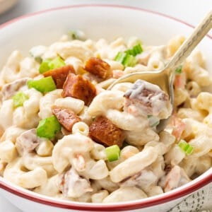 A spoon stirring macaroni Hawaiian salad