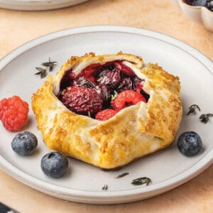 A mini mixed berry galette on a white plate