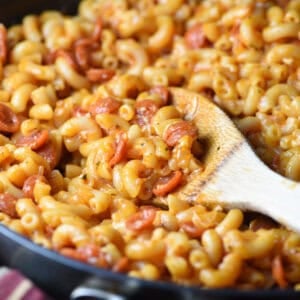 Portion of skillet Macaroni and Cheese on wooden spoon