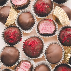 Overhead view of chocolate covered raspberry truffles, some open to show the inside