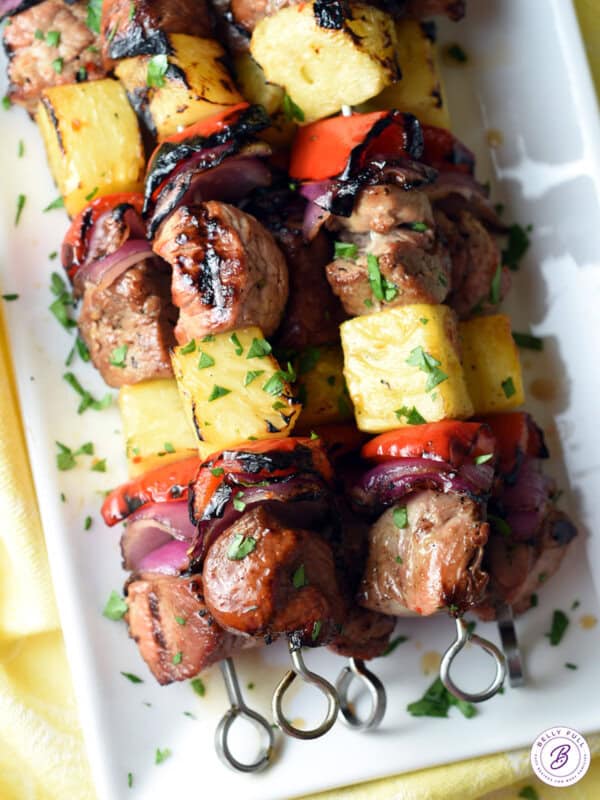 overhead stack of grilled teriyaki pork kabobs on serving tray