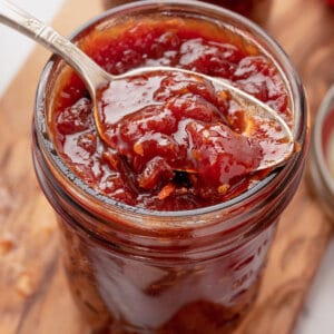 A spoon in a jar of tomato jam