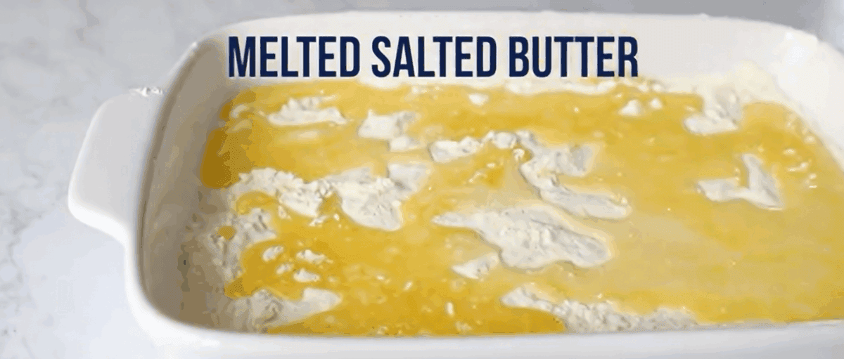 Pouring melted butter over the cake mix.