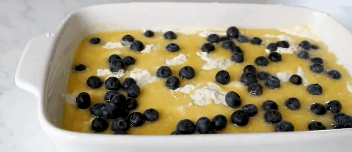 Sprinkling fresh blueberries on top of cake.