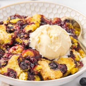 blueberry dump cake in bowl with vanilla ice cream