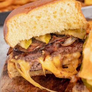 A juicy lucy burger on a bun with pickles