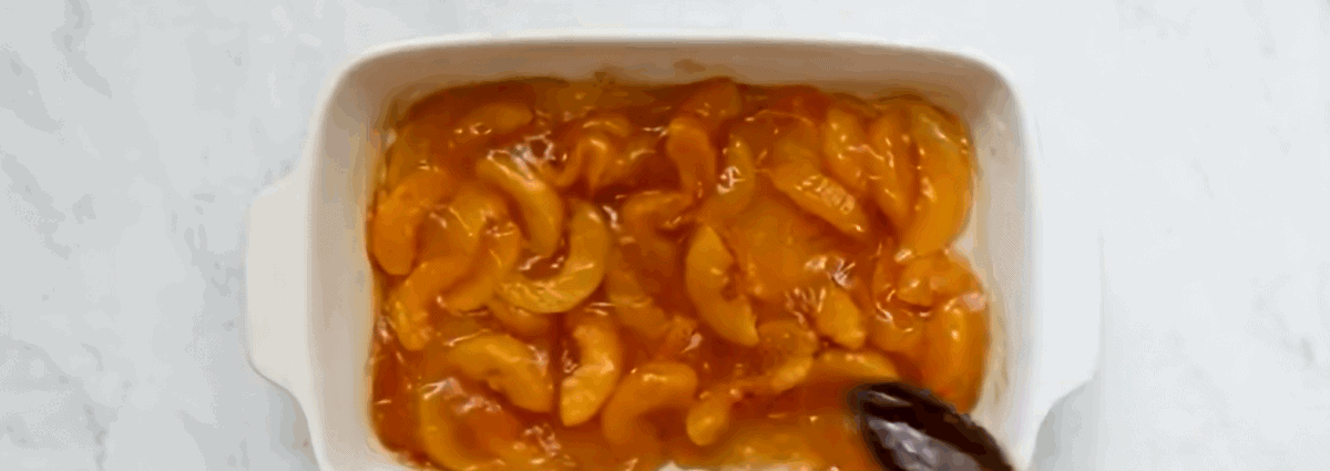 Peach pie filling in a white baking dish.