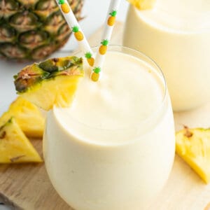 pineapple smoothie with pineapple wedge and straws