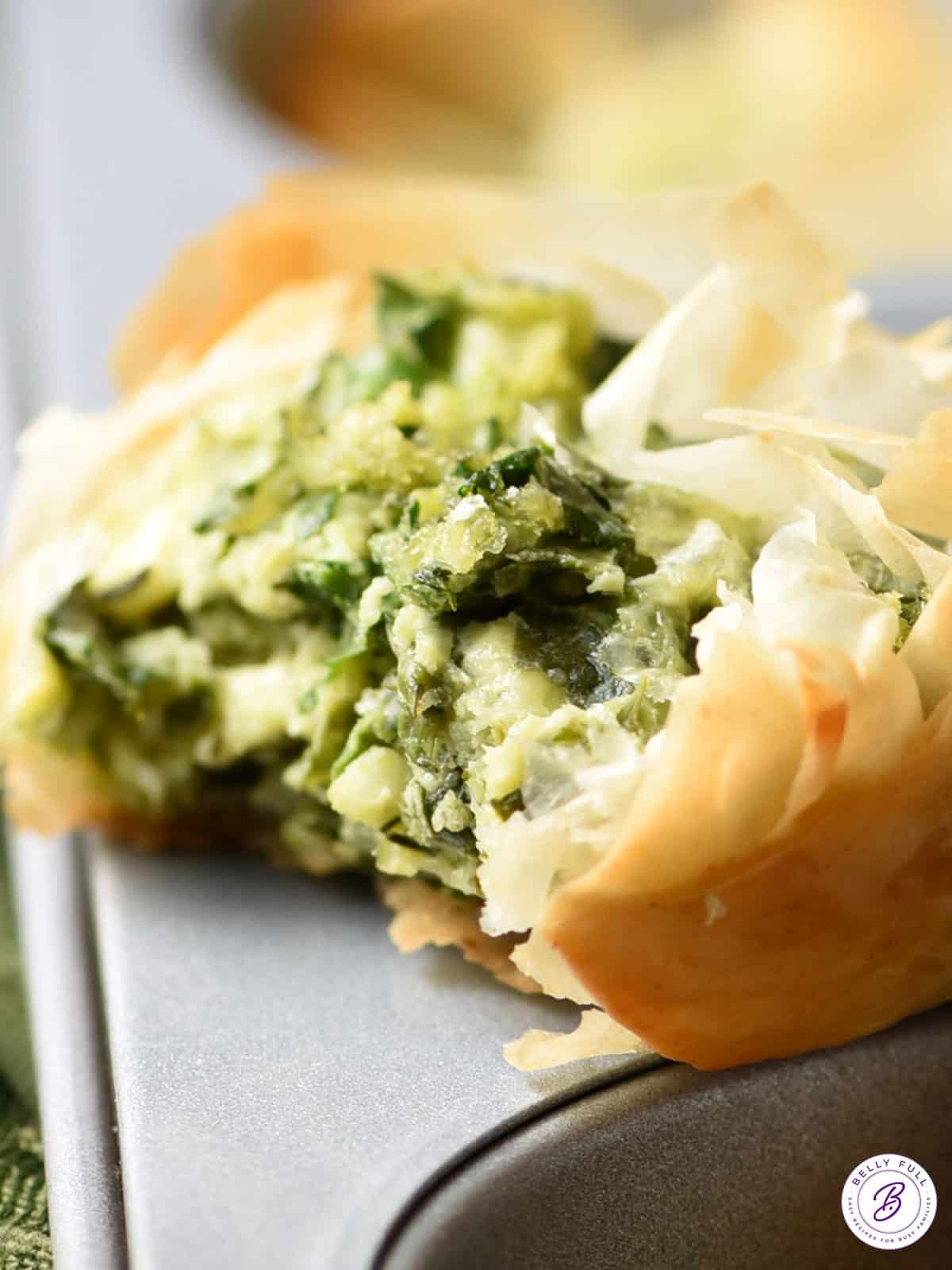 close up Spanakopita Muffin Cup sitting on top of muffin tin