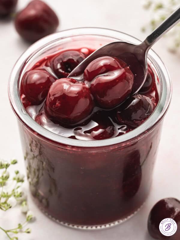 A spoon in a jar of cherry pie filling