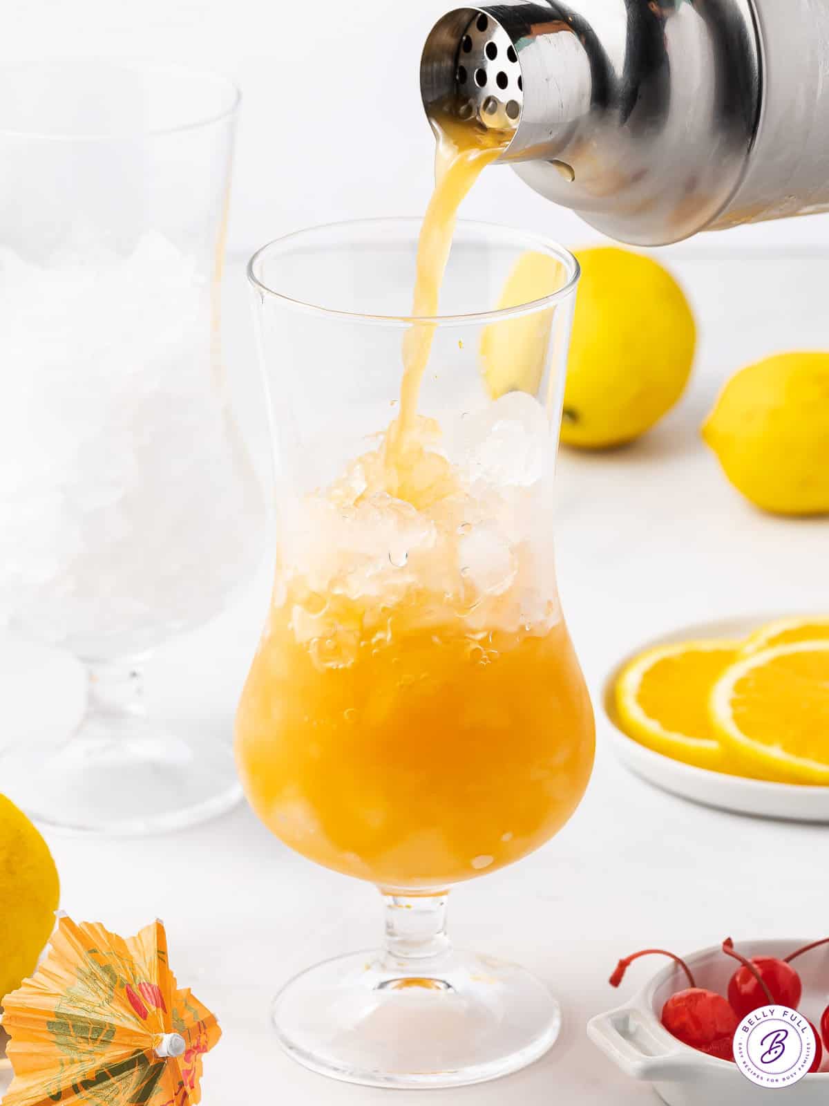 A hurricane drink being poured into a glass