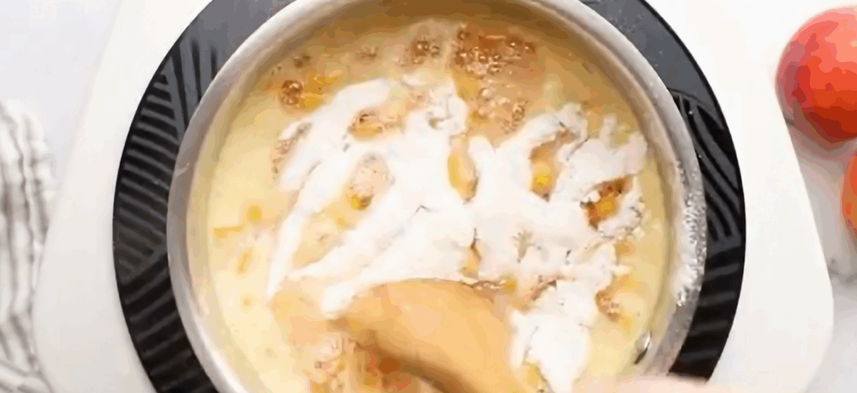 Adding pectin to the fruit mixture in the pot.