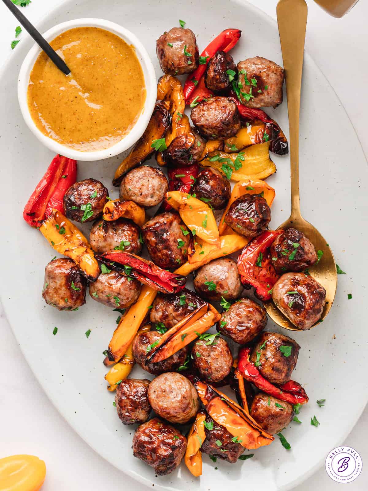 Overhead view of a platter of air fryer bratwurst and peppers