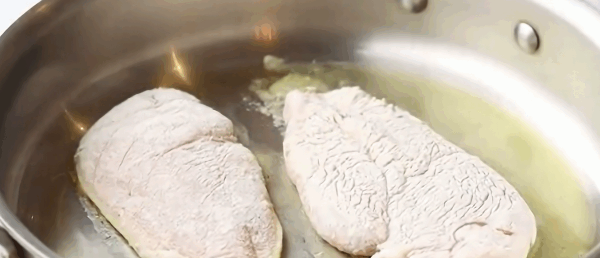 Cooking the seasoned chicken in a skillet. 