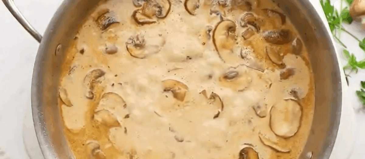The mushroom sauce simmering in a pan.