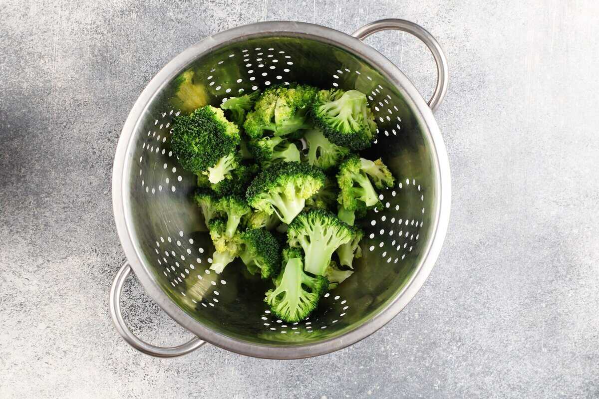 Broccoli florets in a colander.