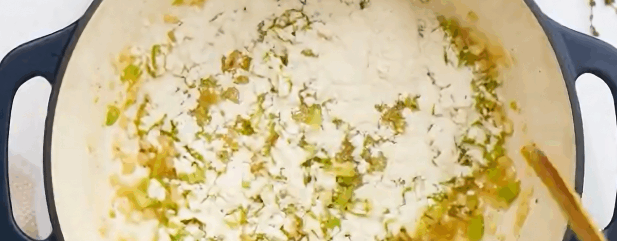 Adding flour to the pot with the veggies. 