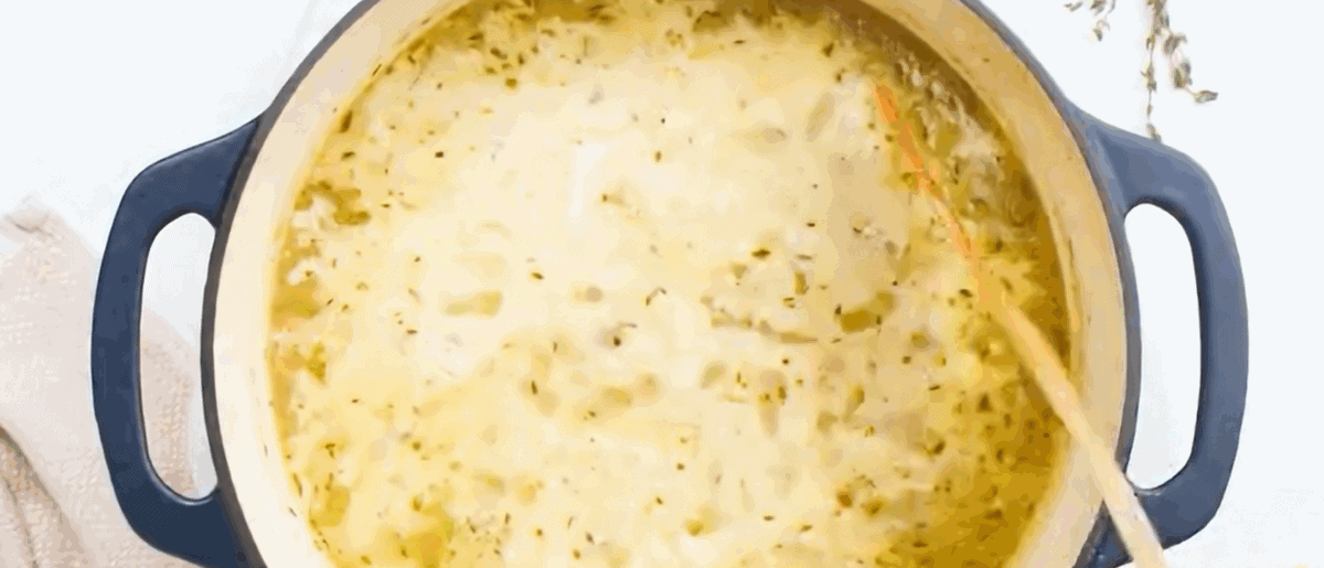 Adding heavy cream to the corn chowder pot and stirring. 