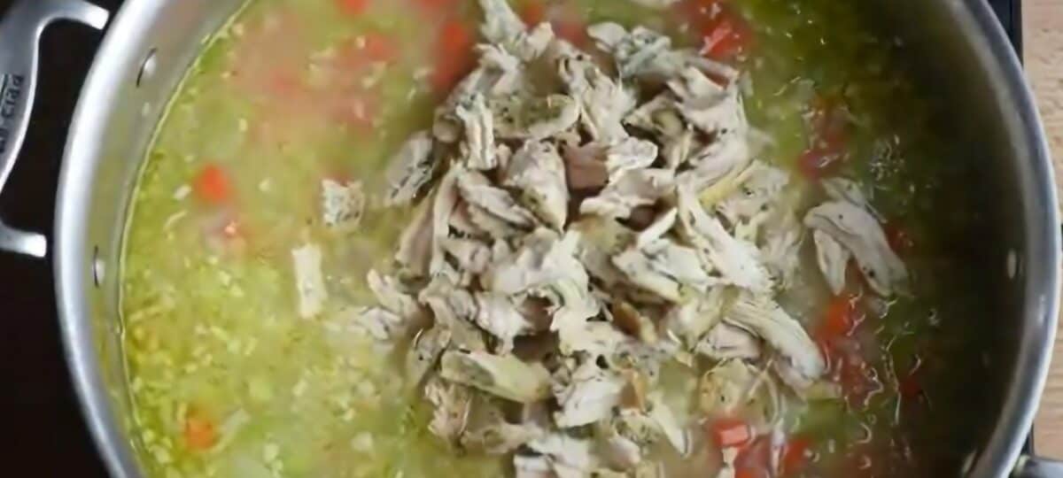 Adding cooked, shredded chicken to the pot.