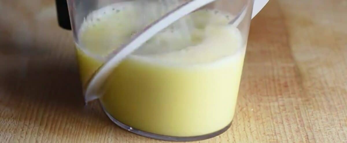 Whisking eggs and lemon juice in a cup.