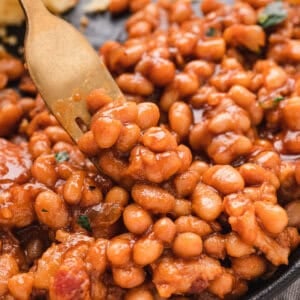forkful of saucy beans with bacon