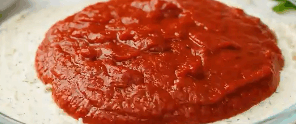 Layering the cheese with pizza sauce.