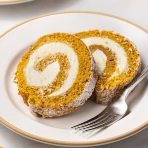Two slices of pumpkin roll on a plate