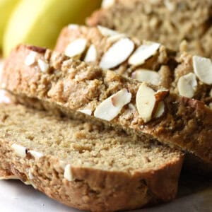 close up slice of banana bread with sliced almonds