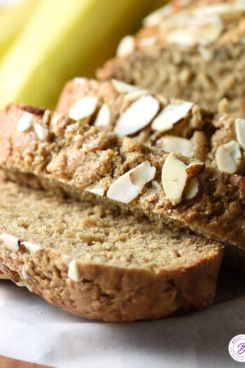 close up slice of banana bread with sliced almonds