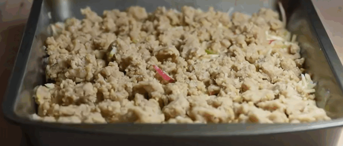 Apple pie bars with the crumble layer on top in a baking pan. 