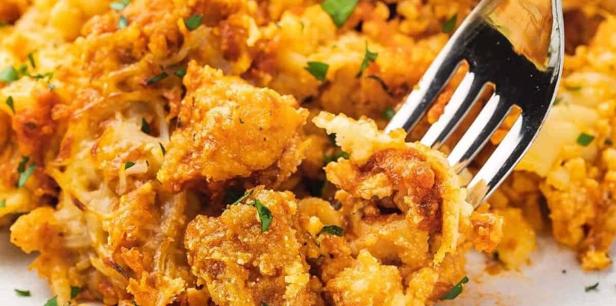 Fork digging into the chicken Parmesan casserole.