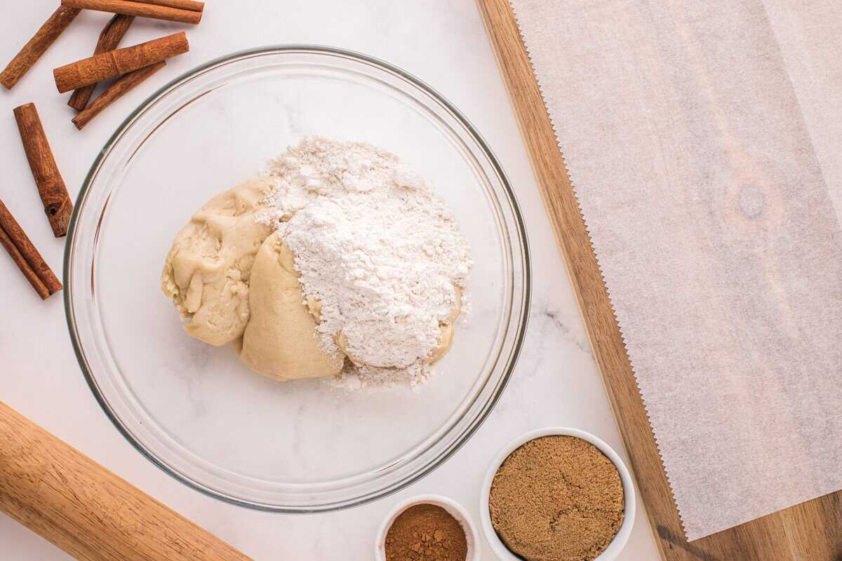 Adding flour to the sugar cookie dough.