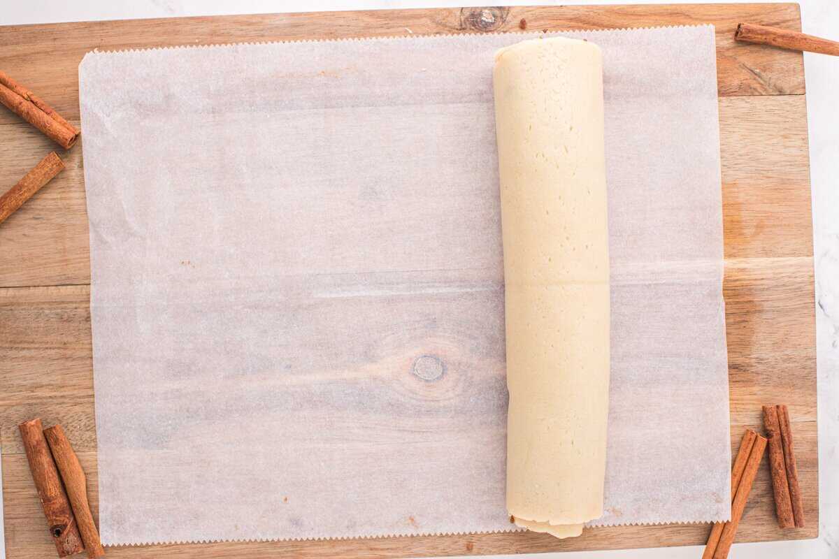 Cookie dough rolled into a log on a piece of parchment paper.