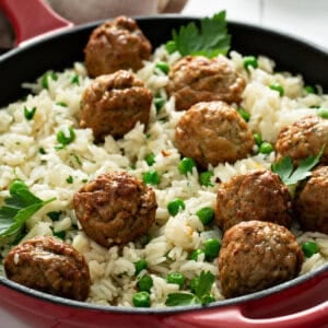 meatballs and rice in skillet with baby peas