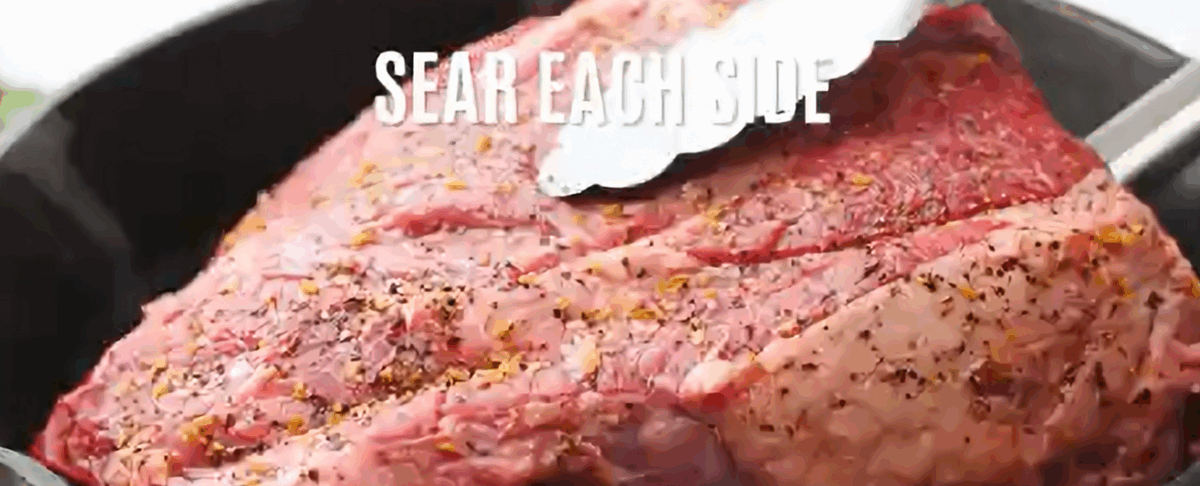 Searing the roast in a pan.