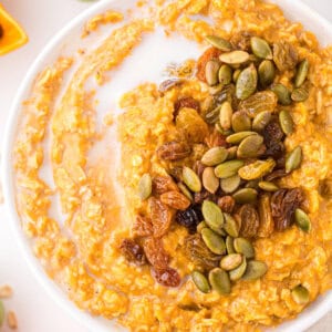 A bowl of pumpkin oatmeal topped with seeds and nuts