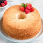 uncut angel food cake topped with berries